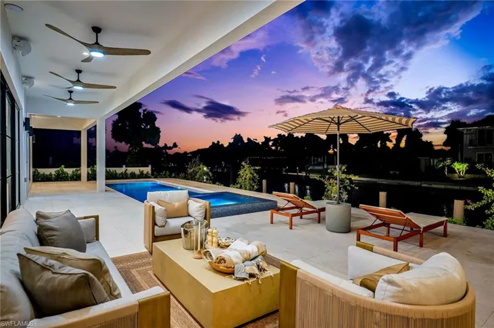 Pool at dusk with an outdoor living space and a patio area