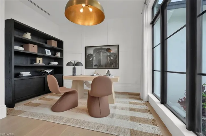 Office with light wood finished floors and a decorative wall