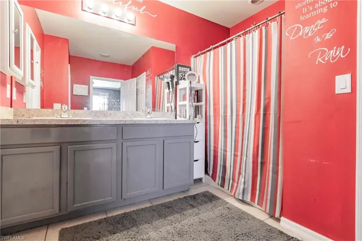 Bathroom featuring tile floors, dual sinks, and large vanity