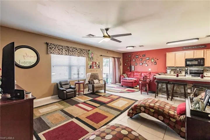 Living room featuring ceiling fan and light tile floors