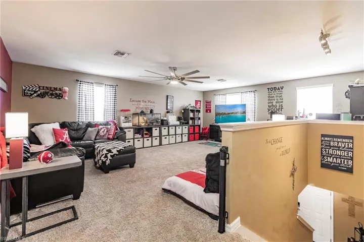 Living room featuring ceiling fan and light carpet