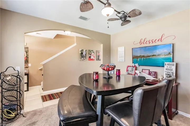 Dining space with ceiling fan and light tile floors