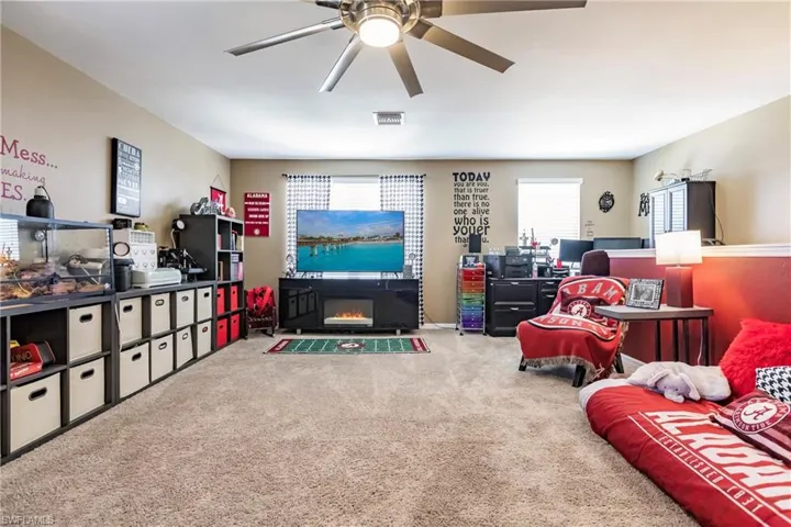 Carpeted living room with ceiling fan