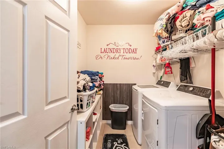 Laundry room with independent washer and dryer and light tile floors