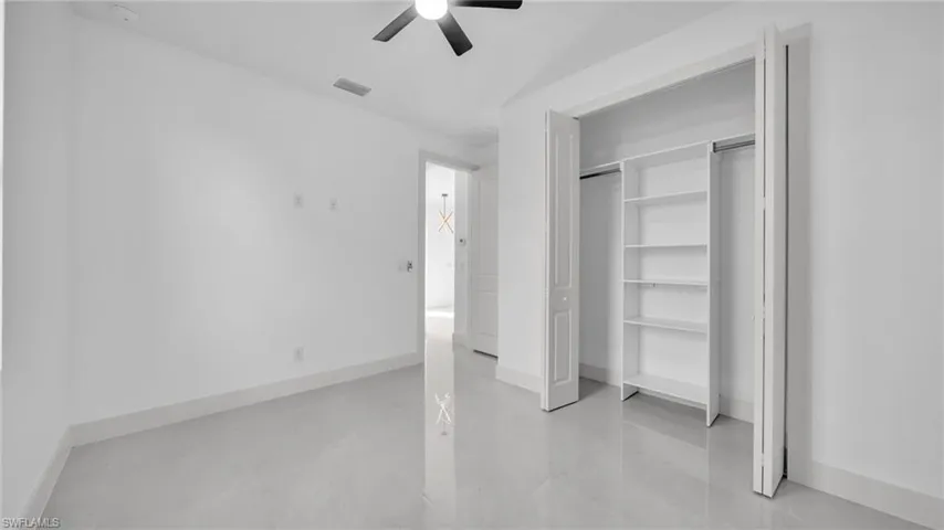 Unfurnished bedroom with a ceiling fan and a closet