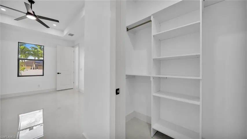 Spacious closet featuring a ceiling fan and light tile patterned flooring
