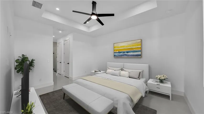 Bedroom with a tray ceiling, finished concrete flooring, a ceiling fan, recessed lighting, and a closet