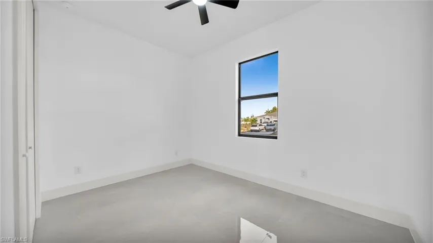 Empty room with finished concrete flooring and ceiling fan