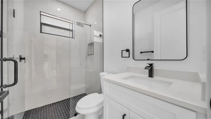 Bathroom with a marble finish shower and vanity
