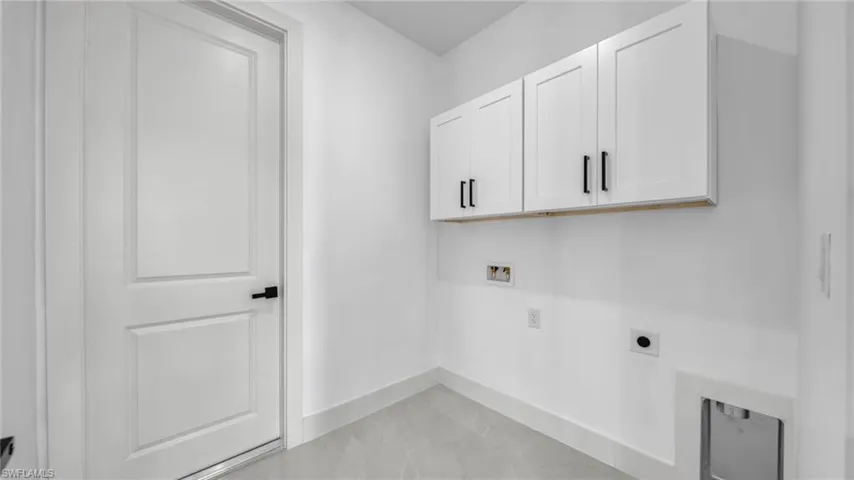 Laundry room with hookup for a washing machine, cabinet space, light marble finish floors, and electric dryer hookup
