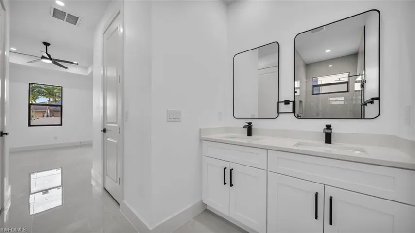 Bathroom with double vanity, recessed lighting, and ceiling fan