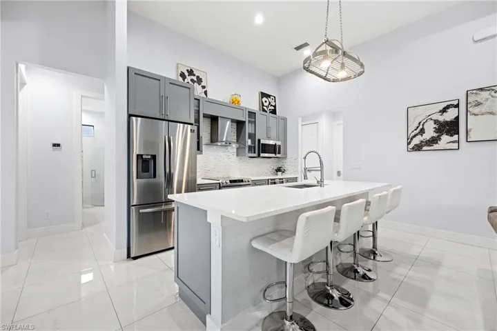 Stylish gray shaker style cabinets, stainless steel appliances & quartz countertops
