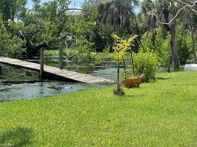 Dock area with a lawn and a water view