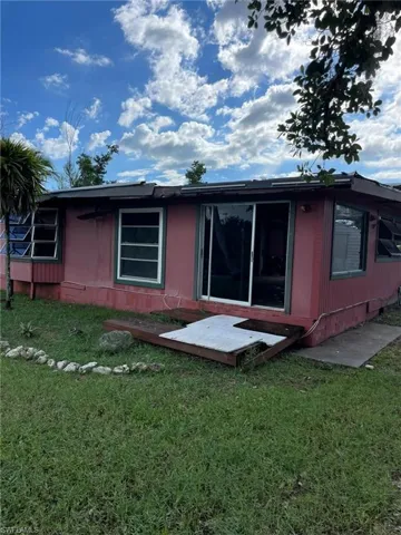 Rear view of property with a yard