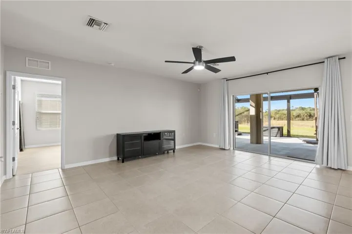 Empty room featuring light tile patterned floors and ceiling fan