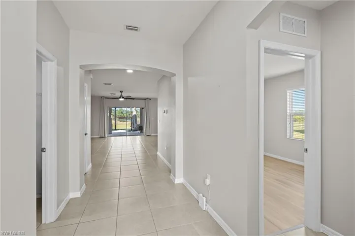 Hall featuring a healthy amount of sunlight and light tile patterned floors