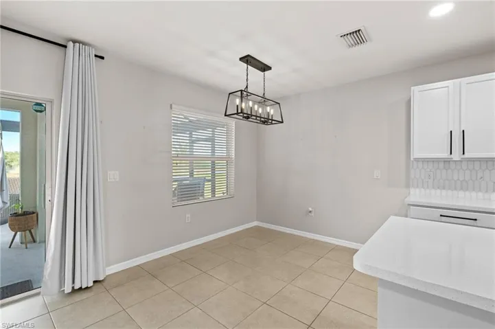 Tiled dining area with a chandelier