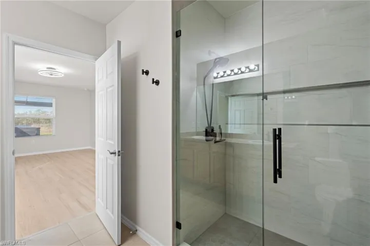 Bathroom with tile patterned flooring and a shower with door