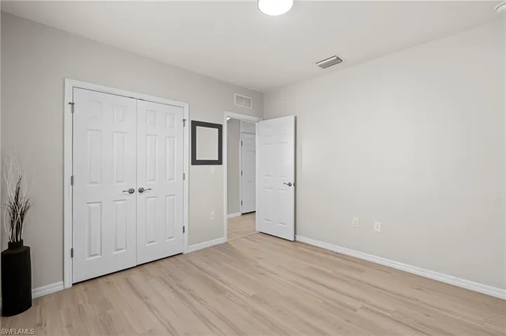Unfurnished bedroom with a closet and light wood-type flooring