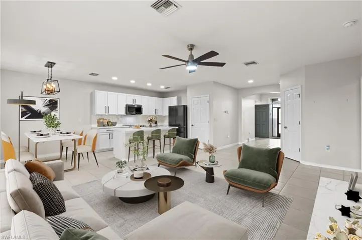 Tiled living room featuring ceiling fan with notable chandelier