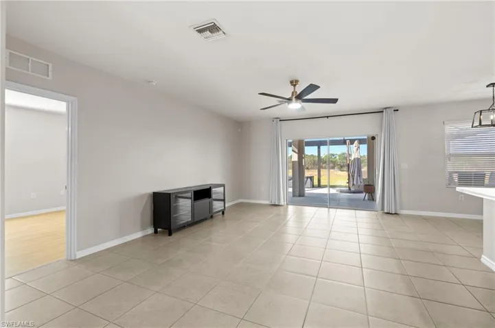 Unfurnished living room with light tile patterned floors and ceiling fan