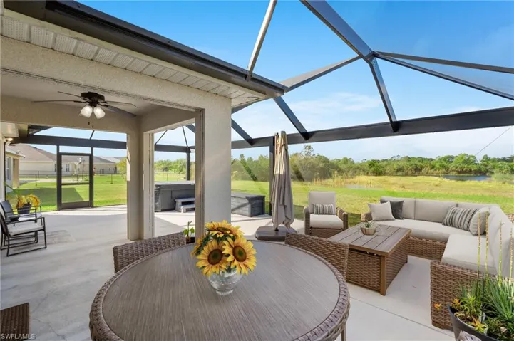 View of patio featuring a lanai, a hot tub, outdoor lounge area, and ceiling fan