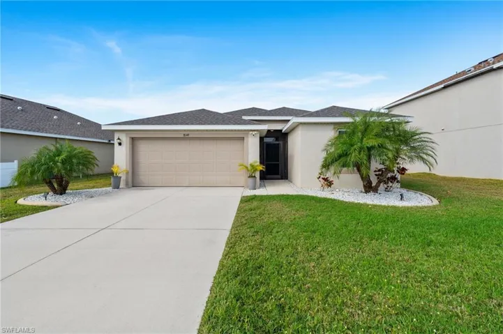 Single story home featuring a garage and a front yard
