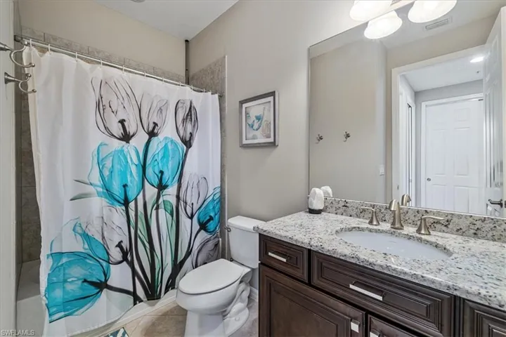 Bathroom featuring tile patterned flooring, vanity, and toilet