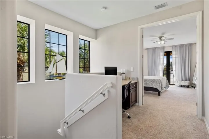 Home office featuring light colored carpet and ceiling fan