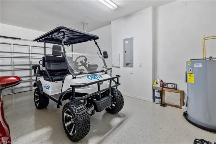 Garage featuring electric panel and water heater