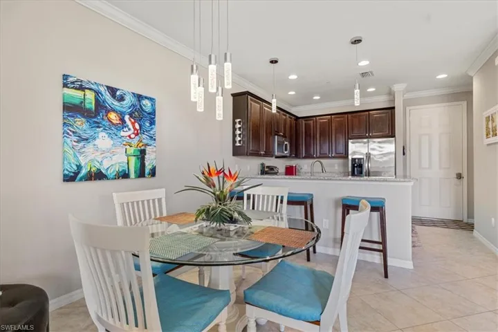 Tiled dining area featuring ornamental molding and sink
