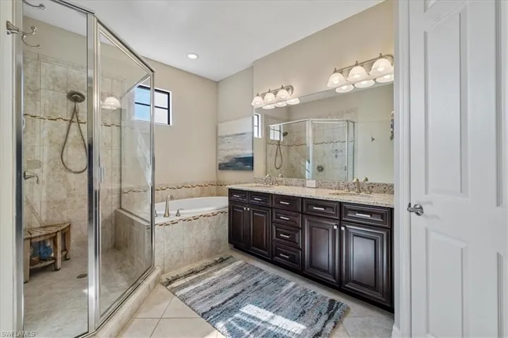 Bathroom featuring tile patterned floors, vanity, and plus walk in shower