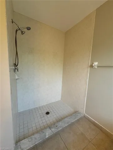 Bathroom with tiled shower and tile floors