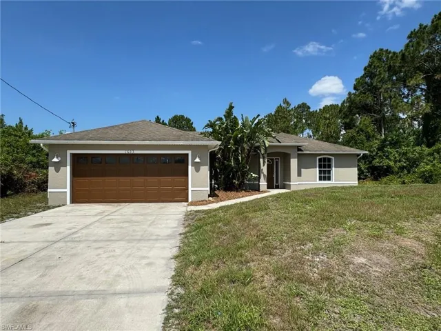 View of front facade featuring a garage and a front yard