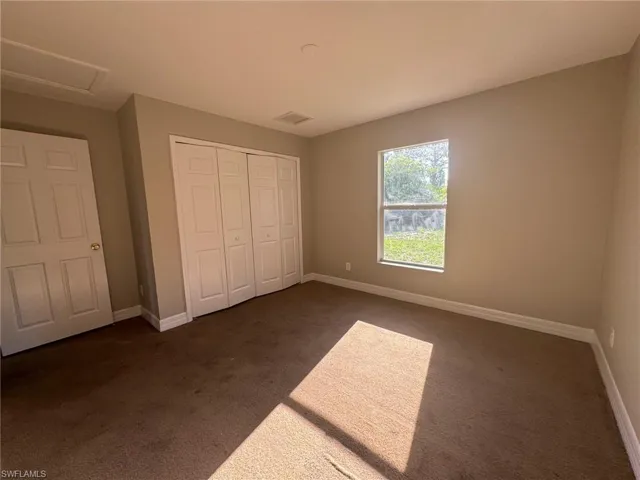 Unfurnished bedroom with a closet and dark colored carpet
