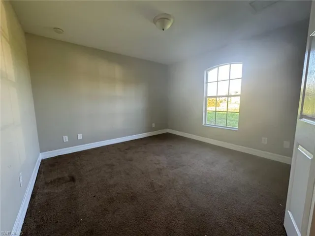 Empty room with dark colored carpet