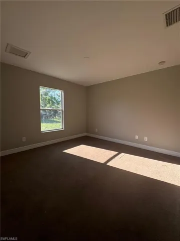 Spare room with dark carpet