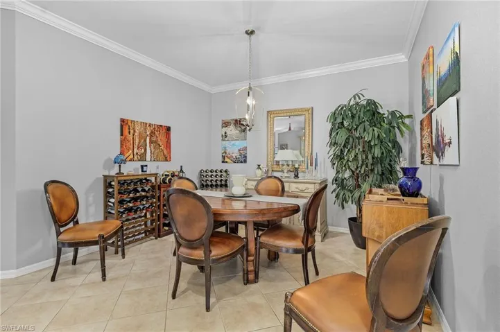 Dining room featuring light tile patterned floors, baseboards, and ornamental molding