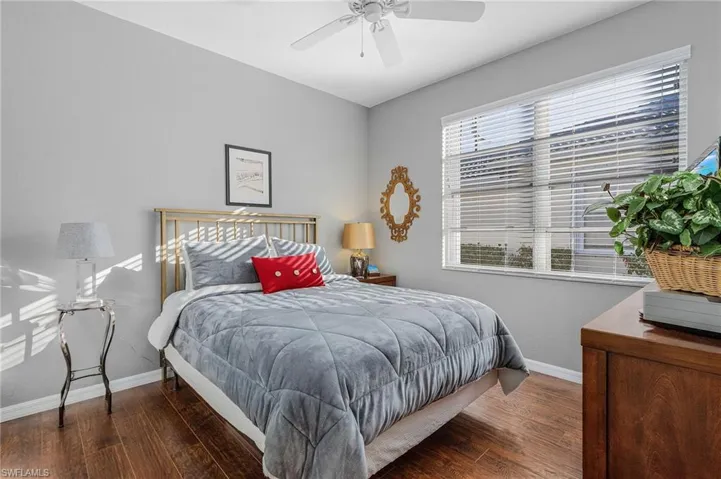 Bedroom featuring a ceiling fan, baseboards, and wood finished floors