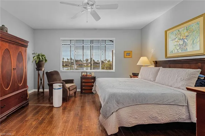 Bedroom featuring baseboards, wood finished floors, and a ceiling fan