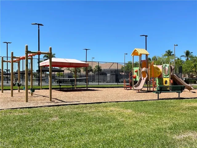 Community play area with a lawn and fence