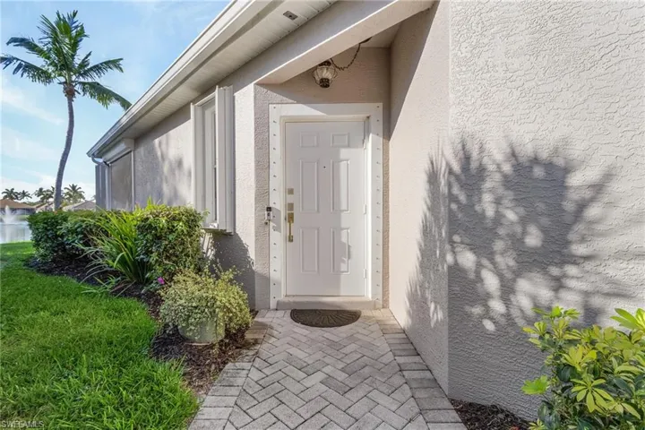 Doorway to property featuring stucco siding