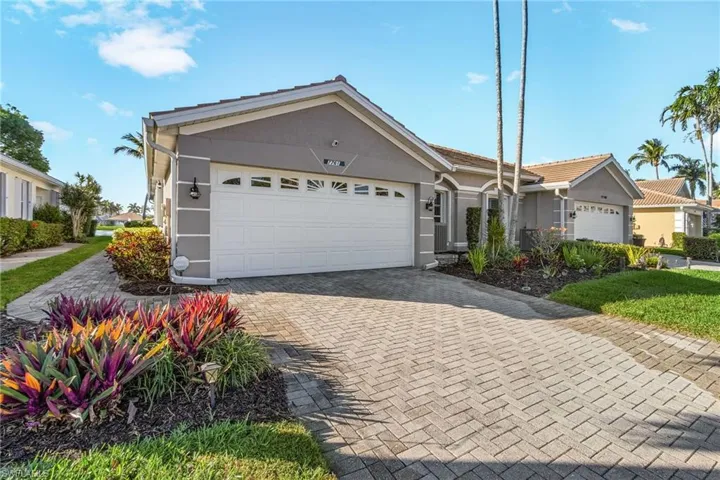 Ranch-style home featuring decorative driveway, an attached garage, and stucco siding