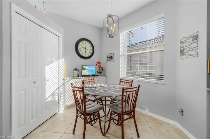 Dining room with light tile patterned floors, baseboards, and an inviting chandelier