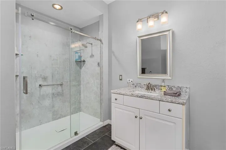 Full bath with vanity and a shower stall