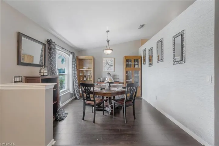 Dining room featuring vaulted ceiling and dark hardwood / wood-style floors