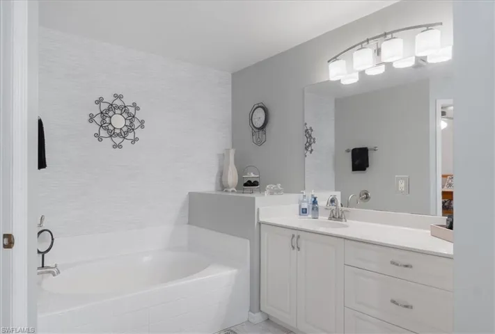Bathroom with a relaxing tiled tub and vanity