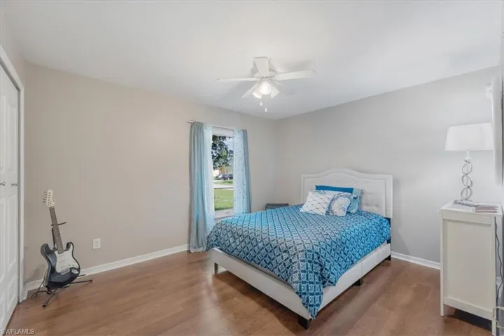 Bedroom with ceiling fan, hardwood / wood-style floors, and a closet