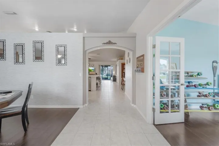 Hall featuring french doors, hardwood / wood-style flooring, and vaulted ceiling