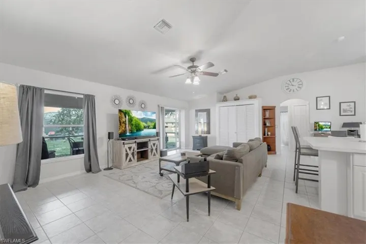 Tiled living room with vaulted ceiling and ceiling fan